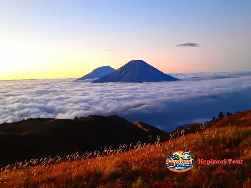 Golden sunrise di puncak Gunung Prau dalam Open Trip Gunung Prau 2 Hari 1 Malam dengan pemandangan pegunungan Jawa Tengah