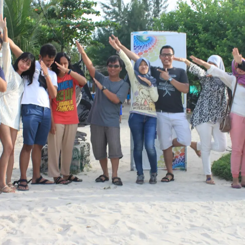 Peserta Open Trip Pulau Pari berfoto bersama sambil menikmati keindahan pantai dan suasana pulau.
