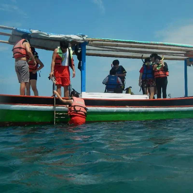 Peserta Open Trip Pulau Pari One Day Trip bersiap menggunakan perlengkapan snorkeling di atas kapal sebelum memulai aktivitas laut.