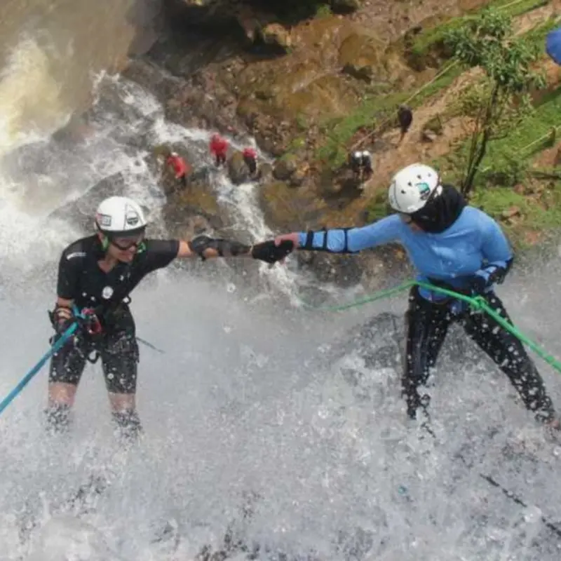 Peserta open trip canyoneering Curug Cikondang sedang melakukan rappelling di air terjun