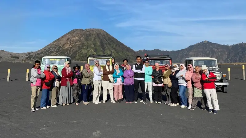 Rombongan wisatawan mengabadikan momen di depan Jeep saat Private Trip Gunung Bromo.