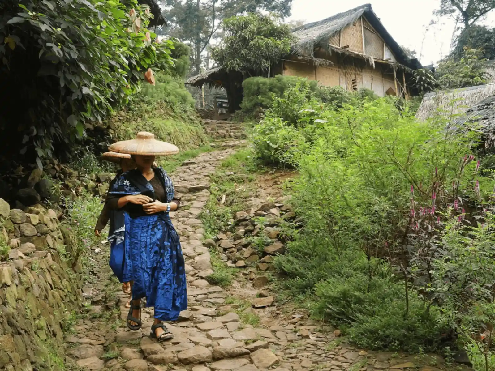 Baduy resident walking down a hillside trail