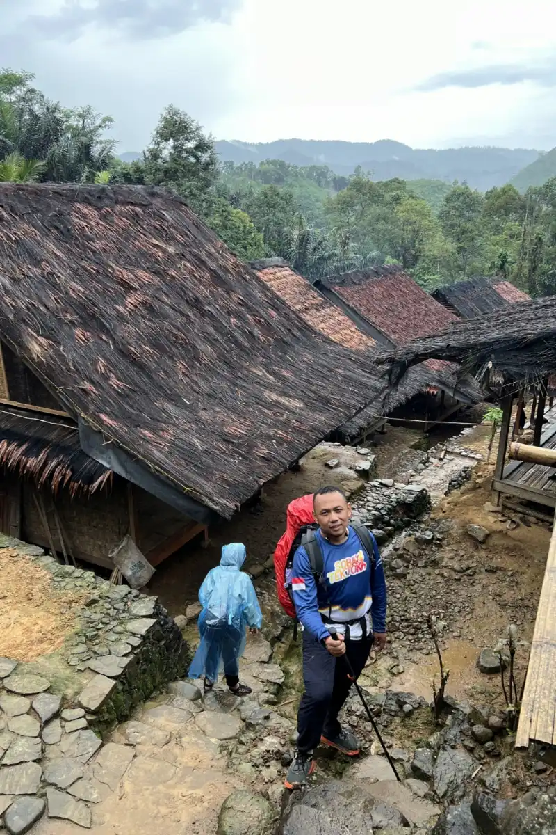 Private trip guests posing in front of a traditional Baduy house