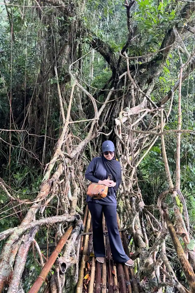 Private trip guests posing on a natural root bridge in Baduy